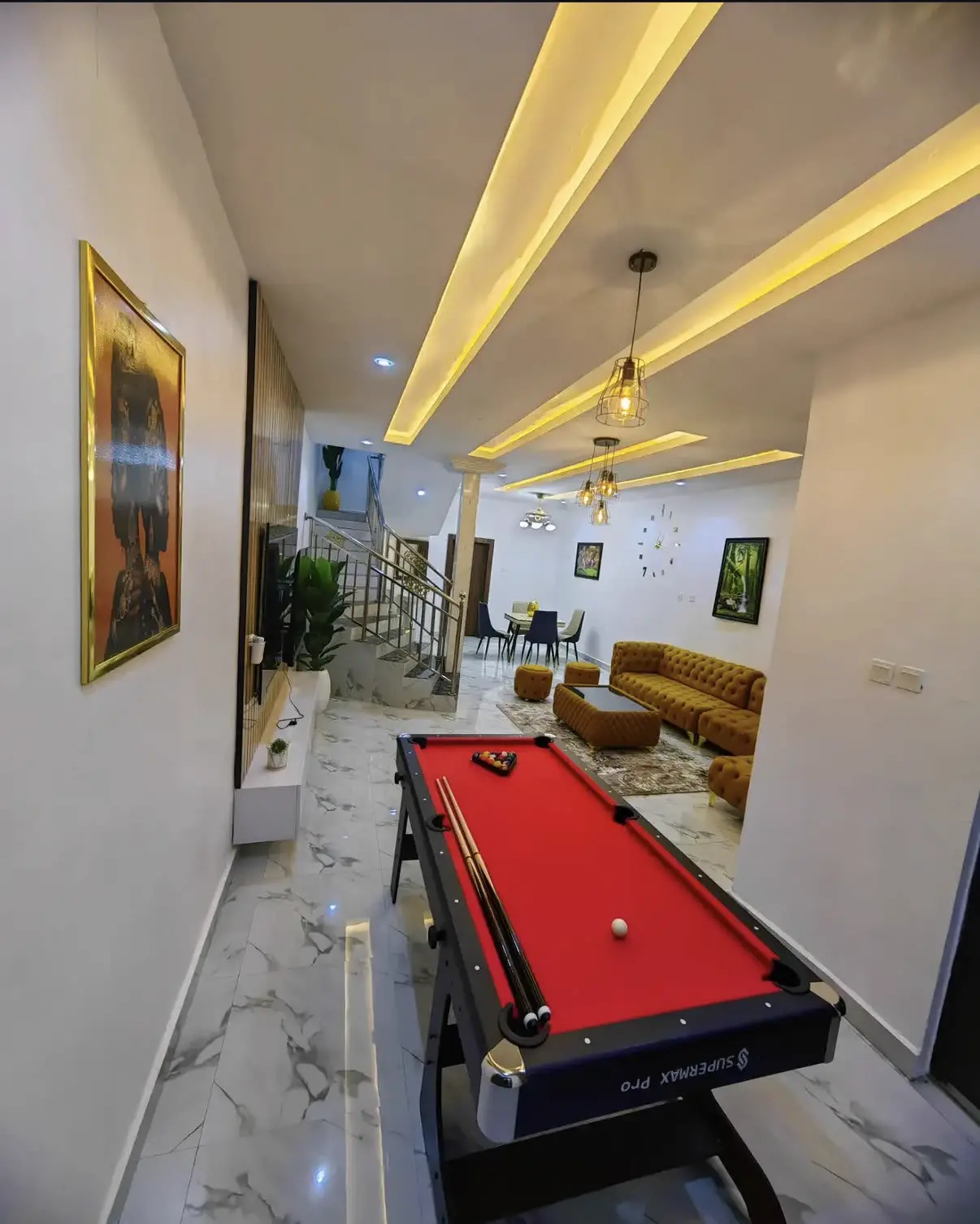 Lounge with red pool table, velvet sofa and warm cove lighting